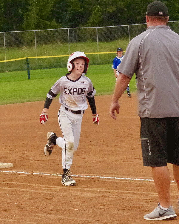 Carter Boos, 11, wore a big grin as he rounded third base after hitting a home run for the Expos, who beat The Blizzard team from the Twin Cities and won the Little League tournament at Wheeler Field. Photo credit: John Gilbert