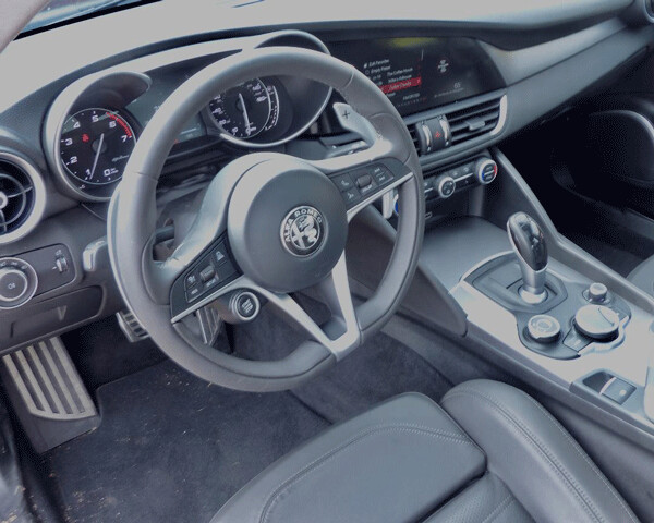 The sporty steering while and leather/aluminum cockpit add to the sporty flair of the Giulia sedan, with either 505-horsepower turbo V6 or 280-horse 2.0-liter 4. Photo credit: John Gilbert