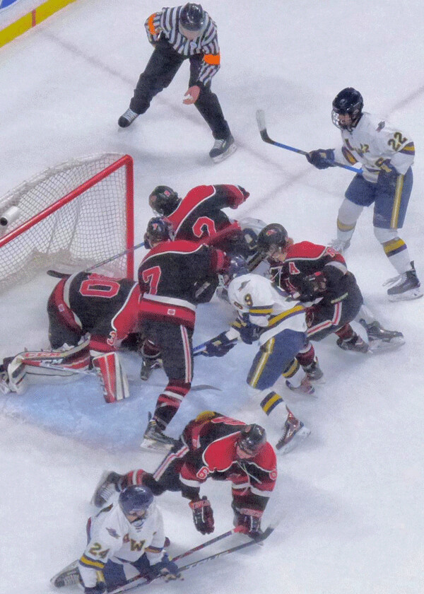 Hermantown’s white-jerseyed Hawks tried their best to attack the Alexandria goal, with Brandon Schmidt (24), Brady Baker, and Elliott Peterson (22) trying to see their way through the cluster of defenders for goalie Jackson Bolilne. Photo credit: John Gilbert