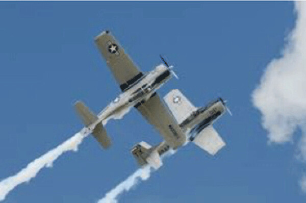 Non-jet engine prop planes doing a close formation stunt at an air show (Note clear blue sky and a “normal cloud” on the photo’s right border) Image from Gary Kohls
