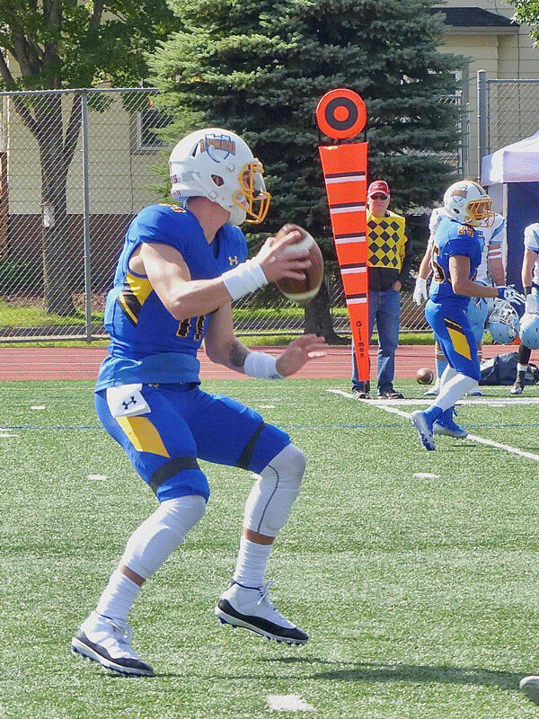 St. Scholastica quarterback Zach Edwards looked for a receiver as he led the Saints to a 23-20 victory over Westminster last Saturday. Photo credit: John Gilbert