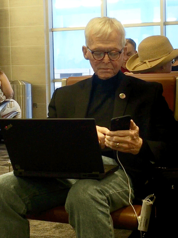Noted auto journalist Tony Swan -- who hated high-tech gadgetry - immersed in it while waiting for a plane in the San Antonio airport just over a year ago. Tony, a Minnesota native, died of cancer last week at age 78. Photo credit: John Gilbert