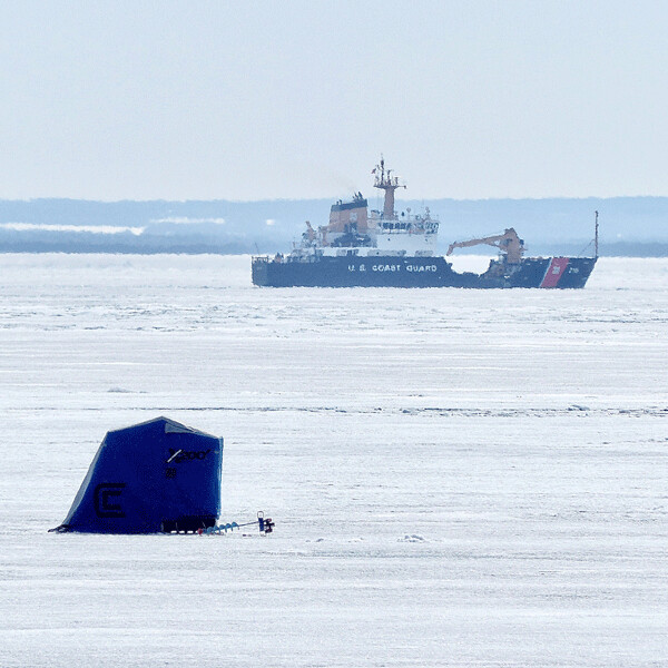 As the Lake Superior ice covering thinned rapidly near Lester River, these ice fishermen were so focused they were unaware that a nearby visitor was breaking a trail through the ice to start the shipping season -- and end the ice fishing season! Photo credit: John Gilbert