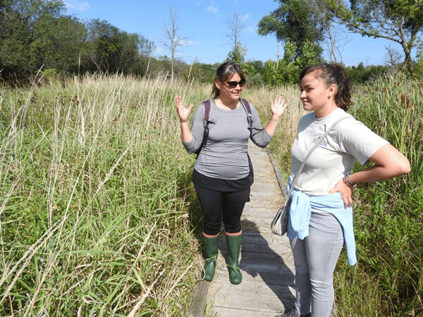 Jenny and Natasha find some stories in nature along the boardwalk at the Kishwauketoe Nature Conservancy. Photo by Emily Stone.