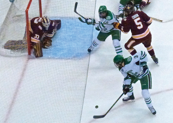 UMD goaltender Kasimir Kaskisuo, without his stick, was set to block a rebound try by North Dakota’s Tucker Poolman in Friday’s 4-2 victory. Photo Credit: John Gilbert