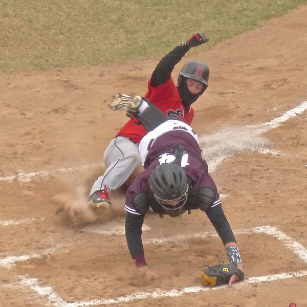 Nathaniel Benson, dressed for the chill, slid home in Duluth East's 3-run first inning of a 4-3 victory over Anoka. East's perfect record ended in the second game. Photo credit: John Gilbert