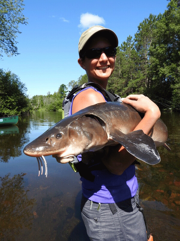 Emily and sturgeon: This is definitely the biggest fish that the author has ever held! Photo by Mike Lins.