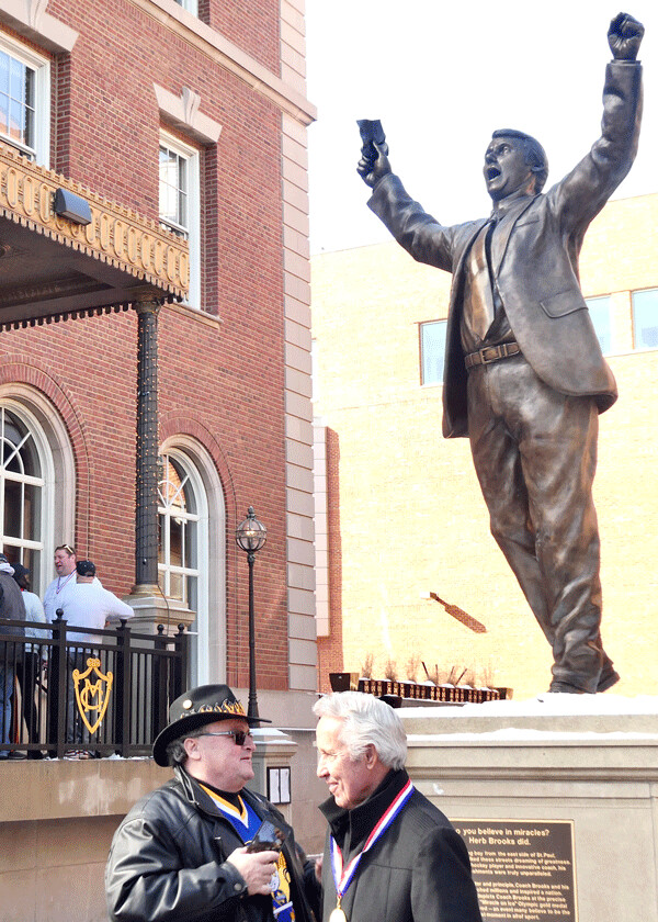 Coordinator David Brooks was interviewed beneath the upraised arms of the statue of his brother, Herb Brooks. Photo credit: John Gilbert